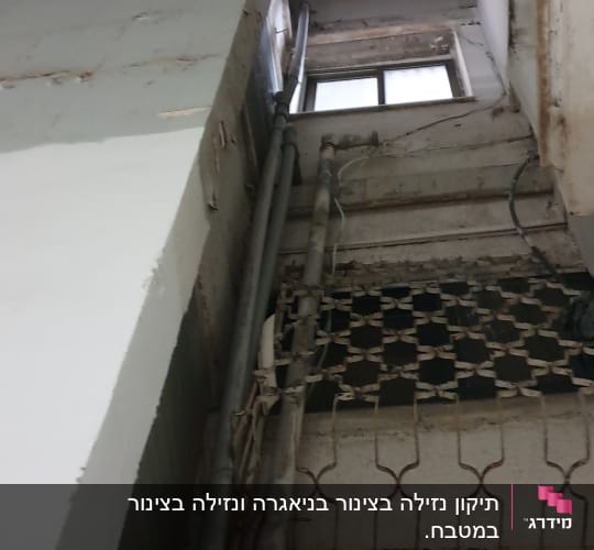 צינורות מתכת מותקנים על קיר חיצוני של בניין